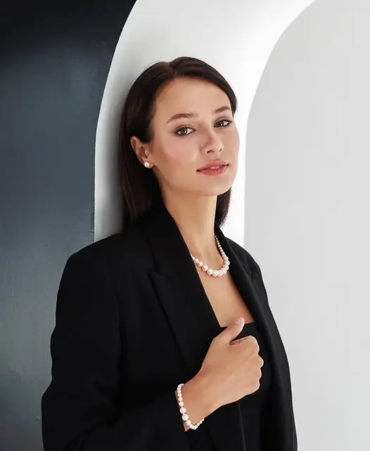 nő elegáns fekete ruházatban Gaura gyöngyékszereket visel